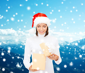 Image showing smiling woman in santa helper hat with gift box