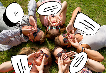 Image showing group of smiling friends lying on grass outdoors