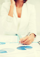 Image showing woman with documents taking phone call