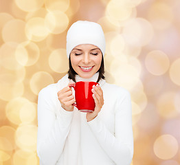 Image showing smiling young woman in winter clothes with cup