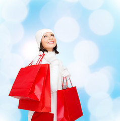 Image showing smiling young woman with red shopping bags