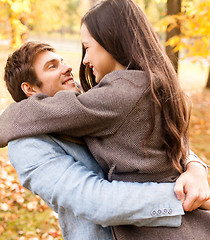 Image showing smiling couple hugging in autumn park