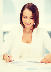 Image showing businesswoman working with graphs in office