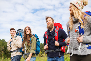 Image showing group of smiling friends with backpacks hiking