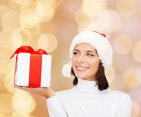 Image showing smiling woman in santa helper hat with gift box