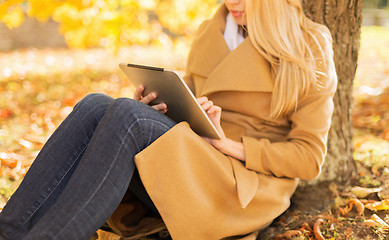 Image showing young woman with tablet pc in autumn park