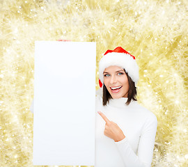 Image showing smiling young woman in santa hat with white board