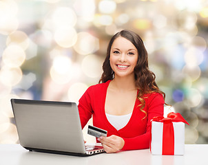 Image showing smiling woman with credit card and laptop