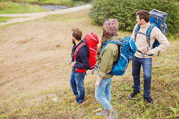 Image showing group of smiling friends with backpacks hiking