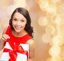 Image showing smiling woman in red dress with gift box