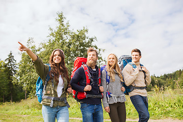 Image showing group of smiling friends with backpacks hiking