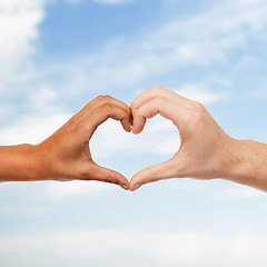 Image showing woman and man hands showing heart shape