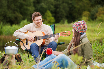 Image showing smiling couple with guitar in camping