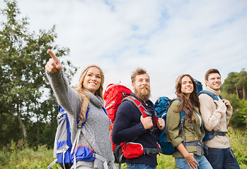 Image showing group of smiling friends with backpacks hiking