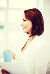 Image showing woman with cup of coffee and papers