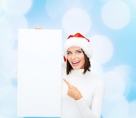 Image showing smiling young woman in santa hat with white board