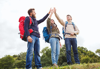 Image showing group of smiling friends with backpacks hiking