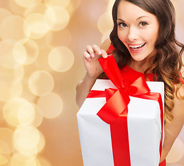 Image showing smiling woman in red dress with gift box