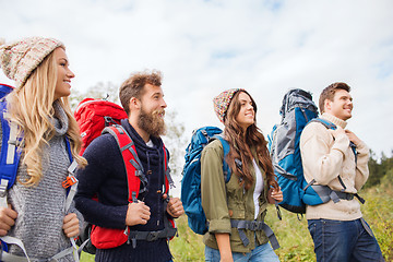 Image showing group of smiling friends with backpacks hiking