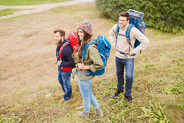 Image showing group of smiling friends with backpacks hiking