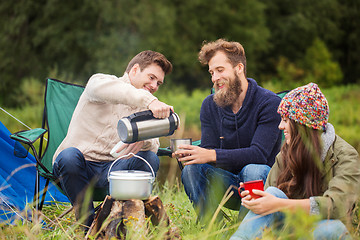 Image showing group of smiling friends cooking food outdoors