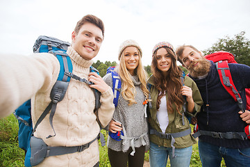 Image showing group of smiling friends with backpacks hiking