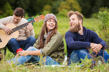 Image showing group of smiling friends with guitar outdoors