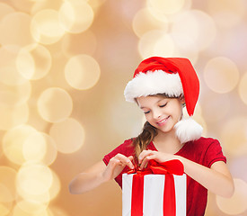 Image showing smiling girl in santa helper hat with gift box