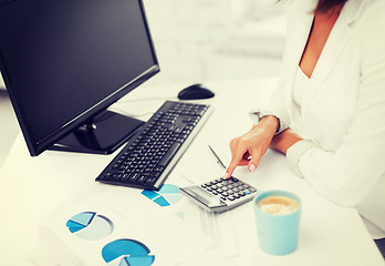 Image showing woman hand with calculator and papers