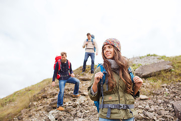 Image showing group of smiling friends with backpacks hiking