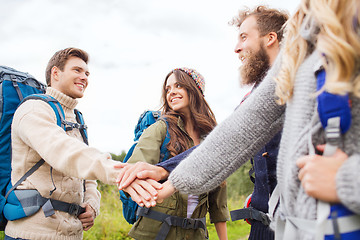 Image showing group of smiling friends with backpacks hiking