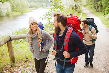 Image showing group of smiling friends with backpacks hiking