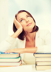 Image showing bored young woman with many books indoors