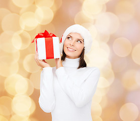 Image showing smiling woman in santa helper hat with gift box