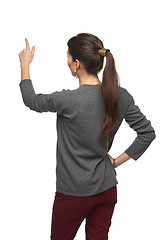 Image showing Back view of woman pointing at copy space