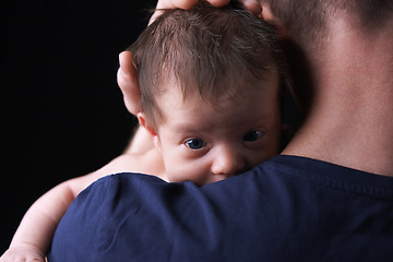 Image showing Newborn baby lying on the father's shoulder