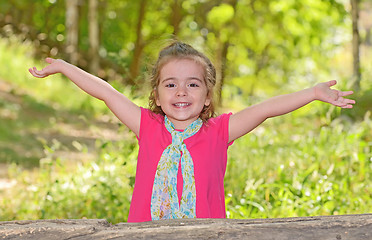 Image showing little girl enjoying and raising her hands 