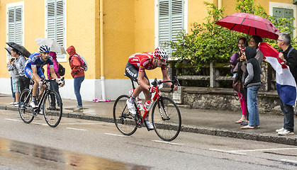 Image showing Two Cyclists Riding in the Rain