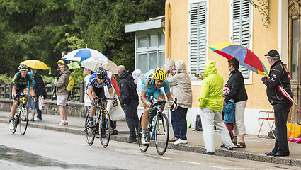 Image showing Three Cyclists Riding in the Rain