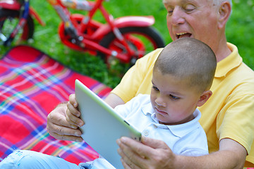 Image showing grandfather and child in park using tablet