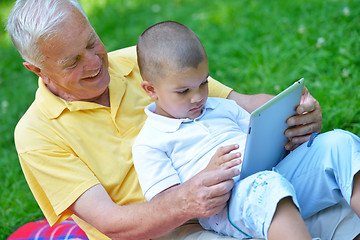 Image showing grandfather and child in park using tablet