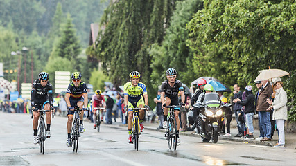 Image showing Four Cyclists Riding in the Rain