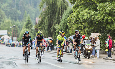 Image showing Four Cyclists Riding in the Rain