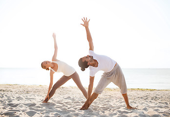 Image showing couple making yoga exercises outdoors