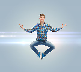 Image showing smiling young man jumping in air