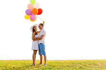 Image showing smiling couple with air balloons outdoors