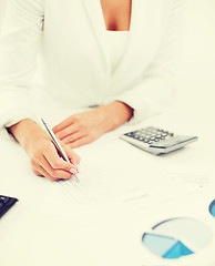 Image showing businesswoman working with calculator in office