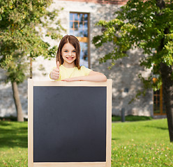 Image showing happy little girl with blank blackboard