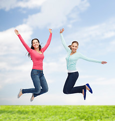 Image showing smiling young women jumping in air