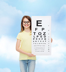 Image showing little girl in eyeglasses with eye checking chart